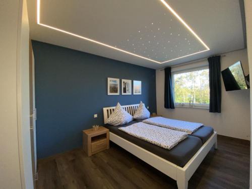 um quarto com uma cama com uma parede azul em Möwenblick - a57230 em Cuxhaven