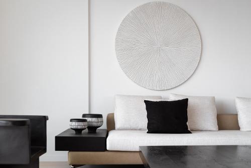 a white living room with a white couch and a mirror at Black Stone Villa in Sounio