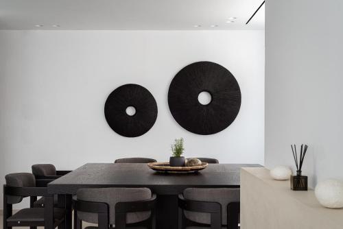 a dining room with a black table and black chairs at Black Stone Villa in Sounio