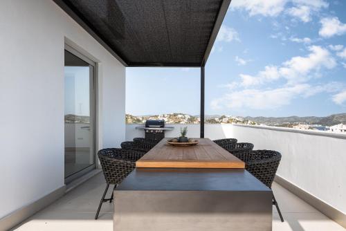 a dining room with a table and chairs on a balcony at Black Stone Villa in Sounio