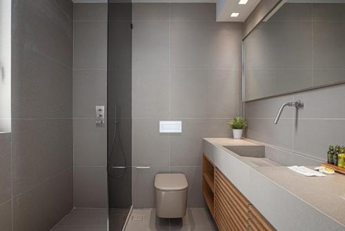 a bathroom with a shower and a toilet and a sink at Black Stone Villa in Sounio