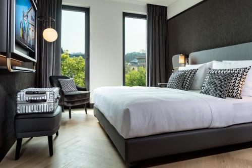 1 dormitorio con 1 cama grande y 1 silla en Hotel Schillerhof, Weimar, en Weimar