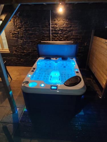 a toilet in a room with a blue bath tub at L'évasion Plaisir Privé SPA in Saint-Pierre-de-Plesguen