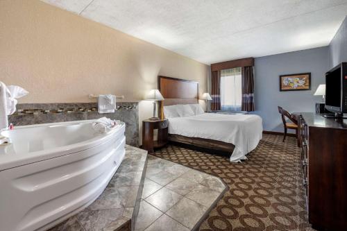 a hotel room with a bed and a bath tub at Econo Lodge in Lafayette