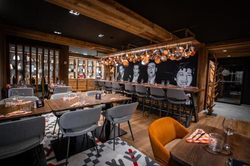 a restaurant with tables and chairs and a bar at Hôtel Névé in Morzine