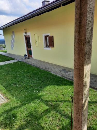 a yellow house with a grass yard in front of it at Ferienhaus Aussicht Gleichenberg in Bad Gleichenberg