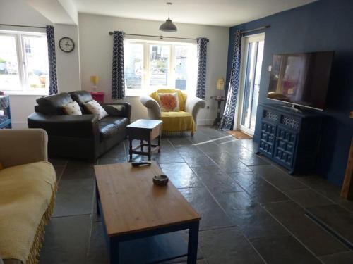 a living room with a couch and a coffee table at Bramble Cottage on the edge of Exmoor in Combe Martin