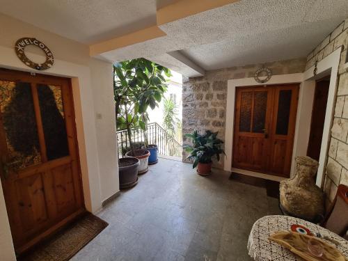a hallway with two wooden doors and potted plants at Beatrix Suites in Budva