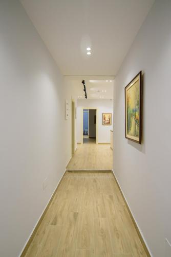 an empty hallway with white walls and a painting on the wall at Palm Side Hotel in Vlorë