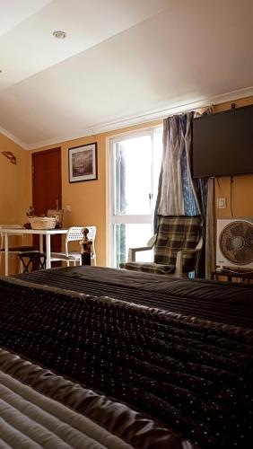 a bedroom with a bed and a large window at Casa de Vasco - Estadia Tranquila e Responsável in Amora