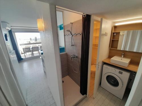 une salle de bain avec douche et machine à laver dans l'établissement Appartement Village Naturiste Lagon, au Cap d'Agde