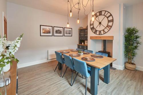 a dining room with a table and a clock at Host & Stay - King's Cottage in Amble