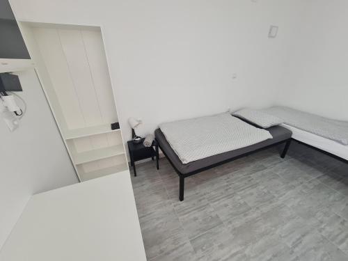 1 dormitorio con 1 cama en una habitación blanca en Budget Apartment LeLo Center1 en Osijek