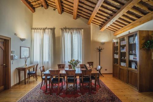 una sala da pranzo con tavolo e sedie in legno di Le Camere di Palazzo Bortolan a Treviso