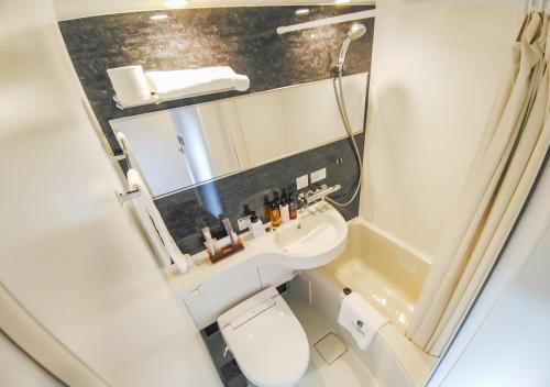 HOTEL LiVEMAX Kokura Ekimae في كيتاكيوشو: حمام صغير مع مرحاض ومغسلة