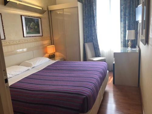 a hotel room with a bed and a desk at Hotel Lugano in Marghera