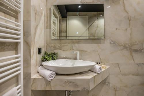 a bathroom with a large white tub and a mirror at Plaza Apartments in Sarajevo