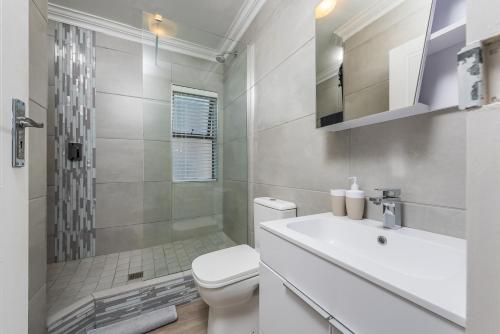 a bathroom with a toilet and a shower and a sink at Beacon Wharf , George Hay 3 Holiday Accommodation in Mossel Bay