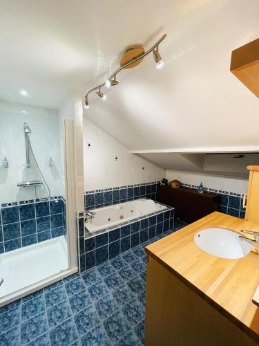 une salle de bain avec une baignoire et un lavabo dans l'établissement Appartement cosy avec jacuzzi à Plaimbois-du-Miroir, 70 m², à Plaimbois-du Miroir