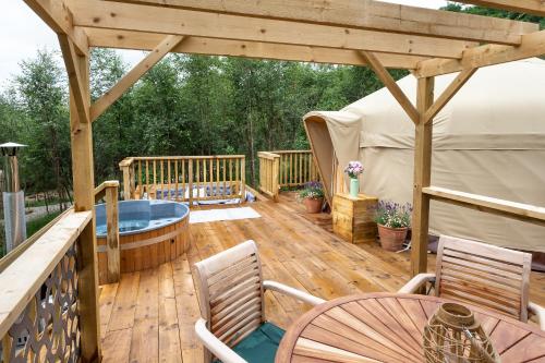 a deck with a hot tub and a gazebo at Yurtshire Eavestone Lake - Birch Yurt in Ripon