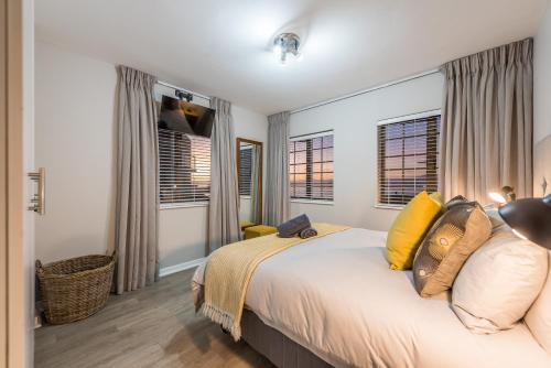 1 dormitorio con 1 cama grande con almohadas amarillas en Beacon Wharf , George Hay 3 Holiday Accommodation, en Mossel Bay