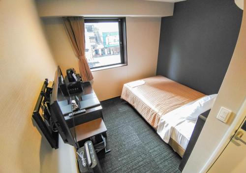 Postel nebo postele na pokoji v ubytování HOTEL LiVEMAX Kokura Ekimae