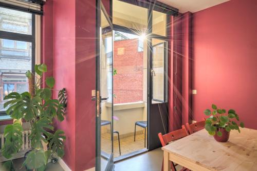 a dining room with red walls and a wooden table at Spacious Apartments in the Heart of Antwerp in Antwerp