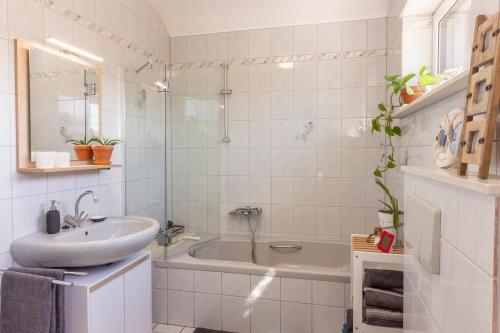 een badkamer met een wastafel en een bad bij Ferienwohnung Kathis Eifelblick in Simmerath