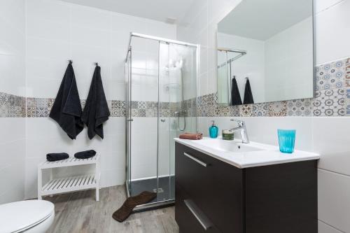 Un baño con ducha, lavabo e inodoro. en Sunset Beach Tarajalejo, en Tarajalejo