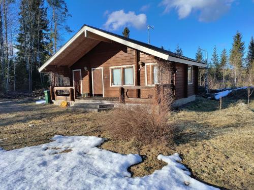 a log house with snow in front of it at Isokummun Foresta in Sievi