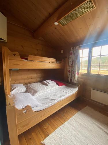 a bed in a wooden room with a bunk bed at Morgedal Camping in Morgedal