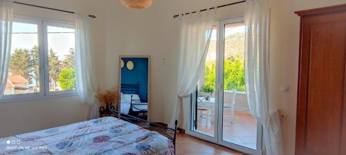 a bedroom with a bed and a sliding glass door at Villa Andoni in Othonoi