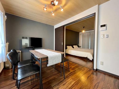 um quarto com uma cama e uma mesa num quarto em リノベーション済み室内新築　Service Apartment Sapporoザ・ハウス4LDK86㎡ em Sapporo