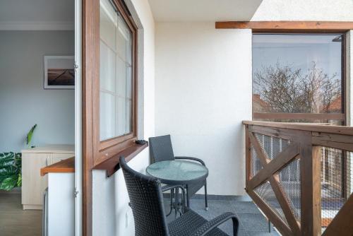 a patio with a table and chairs on a balcony at Rowy Apartamenty Jantar 75 m od plaży in Rowy