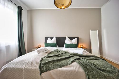 1 dormitorio con 1 cama grande con almohadas verdes en HejU - Parking - Kitchen - Netflix - Kingsize Bett en Lübeck
