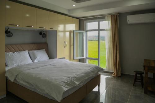 a bedroom with a large bed and a window at Hilar Xezal otel in Ergani
