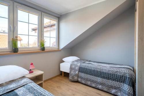 a attic room with two beds and windows at Rowy Apartamenty Jantar 75 m od plaży in Rowy