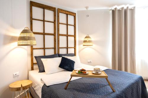 アウグストゥフにあるSzuflada Roomsのベッドルーム1室(ベッド1台、フルーツ付きのテーブル付)