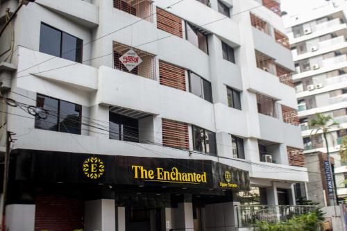 a white building with a sign that reads the enchanted at Hotel The Enchanted in Dhaka