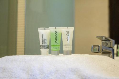 a couple of bottles of sunscreen sitting on top of a sink at Hotel The Enchanted in Dhaka