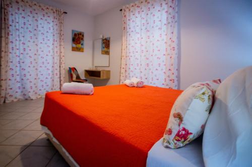 a bedroom with a red bed with towels on it at Porto Gerakas Villas in Vasilikos