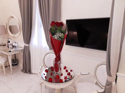 a vase with roses on a table in a living room at The Moon Boutique Hotel & Spa in Florence
