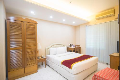 a hotel room with a bed and a television at Hotel The Enchanted in Dhaka