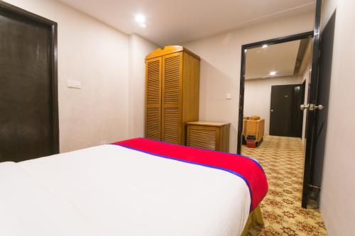 a bedroom with a white bed and a closet at Hotel The Enchanted in Dhaka