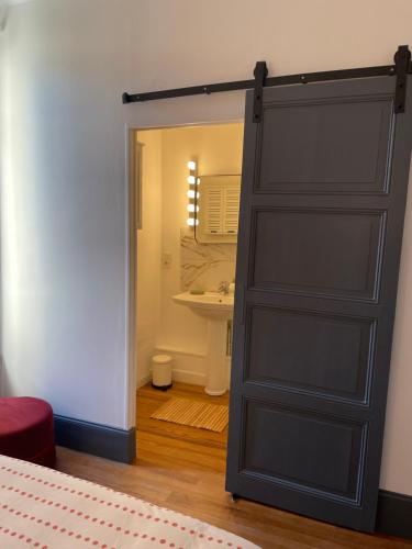 - une porte menant à une salle de bains pourvue d'un lavabo dans l'établissement Appartement au calme et bow window quartier plage, à Mers-les-Bains