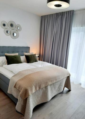 a bedroom with a large bed and a large window at Apartamenty na Spokojnej in Kołobrzeg