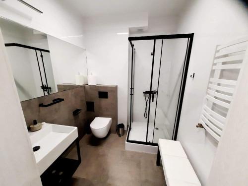 a bathroom with a shower and a toilet and a sink at Apartamenty na Spokojnej in Kołobrzeg