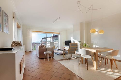a kitchen and dining room with a table and chairs at Stunning Sea View Apartment Praia D'El Rey in Casal da Lagoa Seca