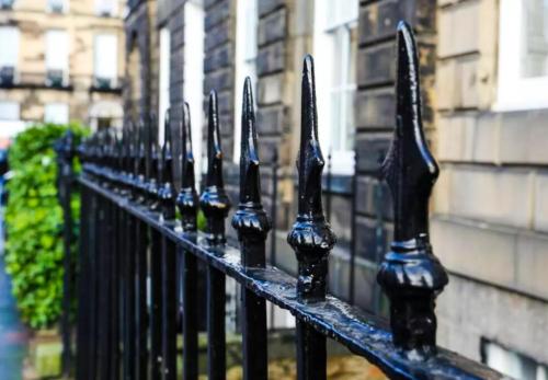a black wrought iron fence in front of a building at Ultra Modern, Stylish Apartment Next To Princes St in Edinburgh