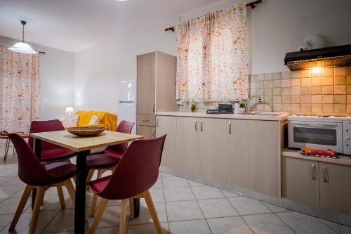a kitchen with a table and chairs and a microwave at Porto Gerakas Villas in Vasilikos
